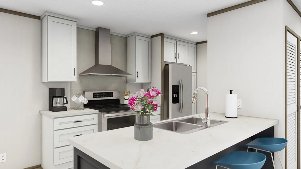Modern kitchen with white cabinets, stainless steel appliances, an island with a sink, two blue barstools, and a vase of pink flowers on the countertop.