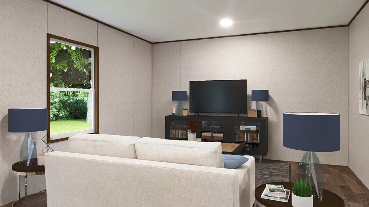 b2305e81-6930-42c3-9c79-8440badb2864 A living room with a white sofa, two blue table lamps, a TV on a black console, bookshelves, a wooden coffee table, and a window showing greenery outside.