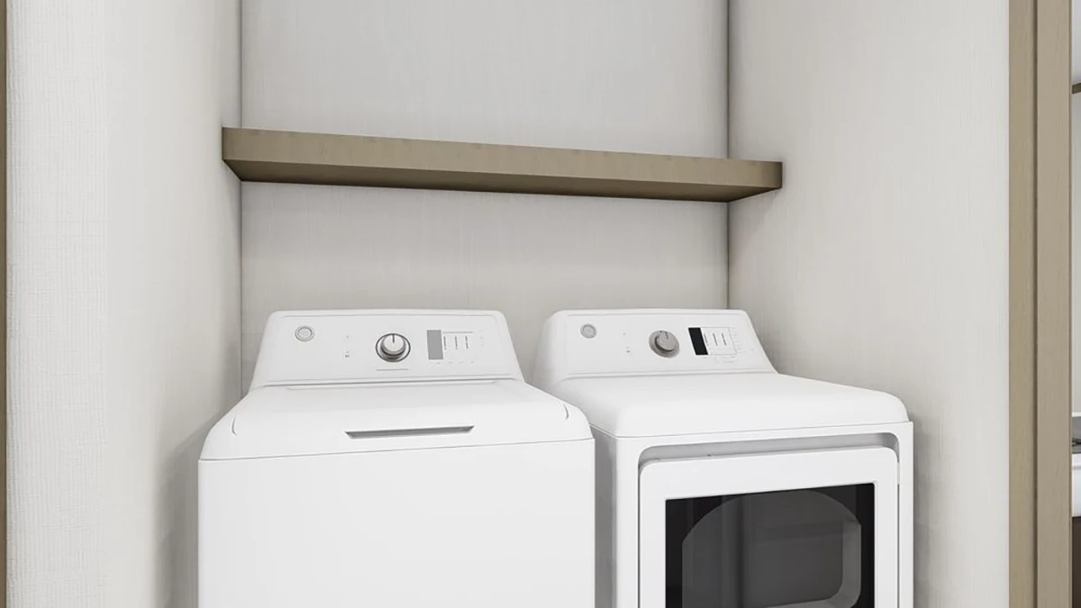 A white washing machine and dryer are placed side by side in a recessed laundry area with a wooden shelf above them.