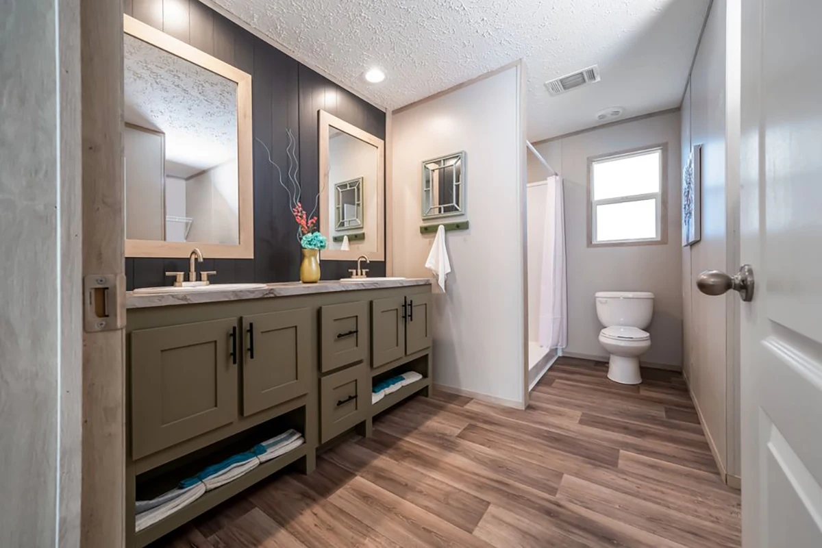 Modern bathroom with double sink vanity, two mirrors, wall sconces, open shelving below, a toilet, a shower with a white curtain, and wood-style flooring.