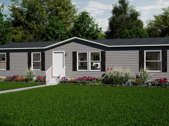 A single-story gray manufactured home with black shutters, a central white door, a small front porch, and a well-kept lawn bordered by flower beds and shrubs.