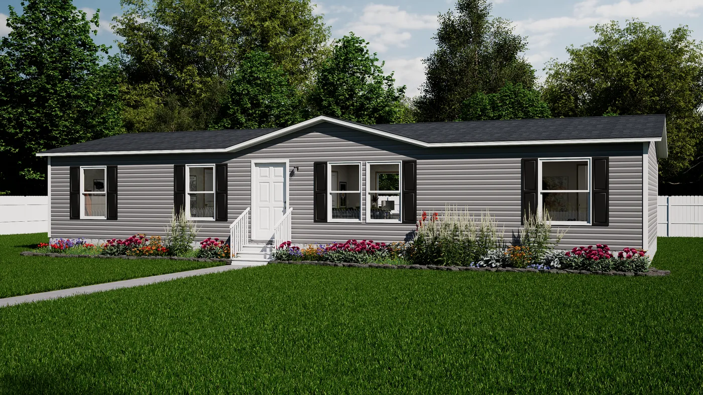 A single-story gray manufactured home with black shutters, a central white door, a small front porch, and a well-kept lawn bordered by flower beds and shrubs.