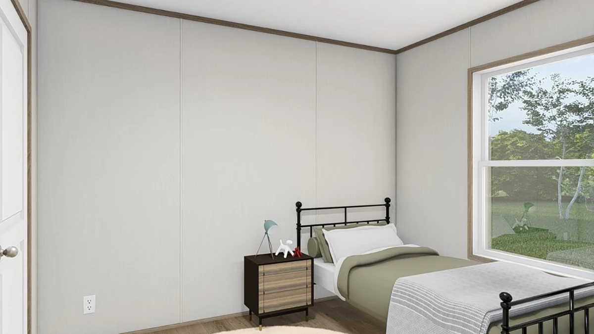 A small, minimalist bedroom with a single bed, a nightstand with a lamp and decor, light-colored walls, wooden floor, and a large window showing greenery outside.