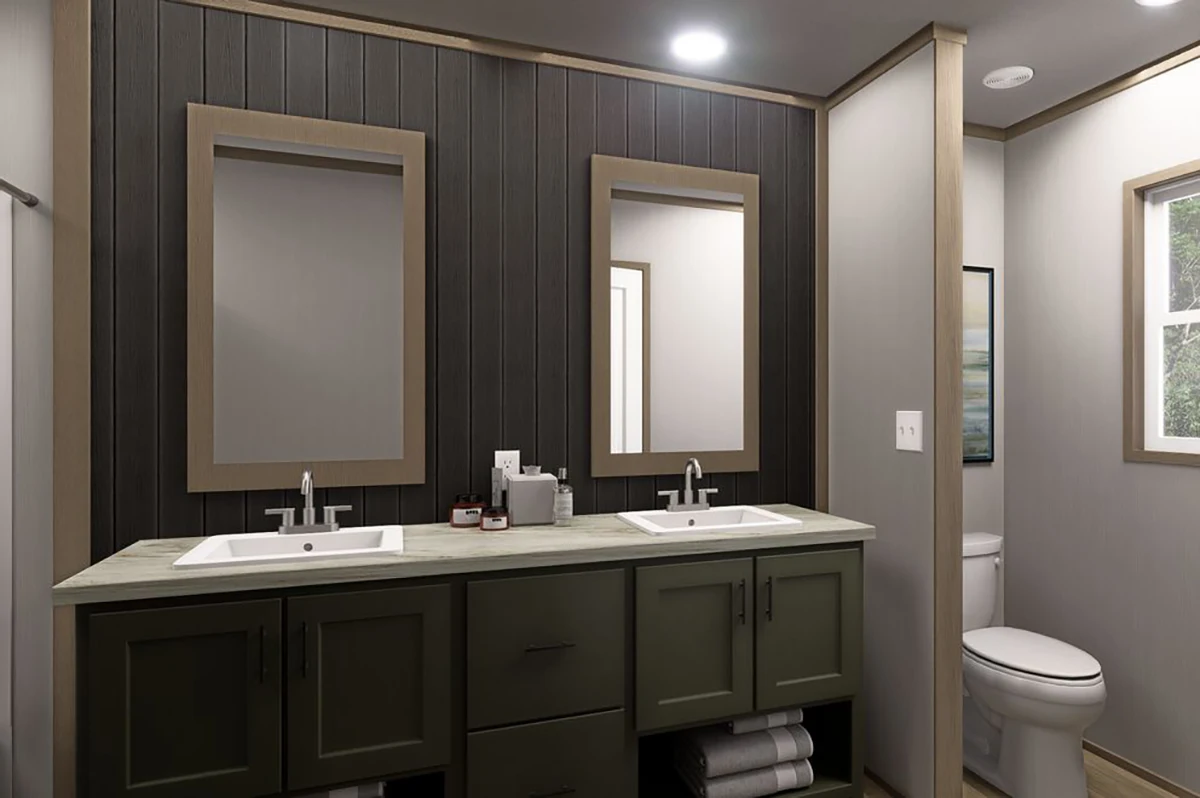 Modern bathroom with double sinks, two mirrors, dark wood paneling, green cabinets, and a separate area for the toilet. Towels are stored in open shelves below the sinks.