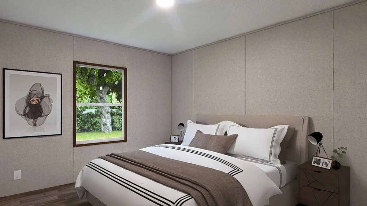 A neatly made bed with white and beige linens is centered in a small bedroom with a window, two nightstands, lamps, and a framed artwork on the wall.