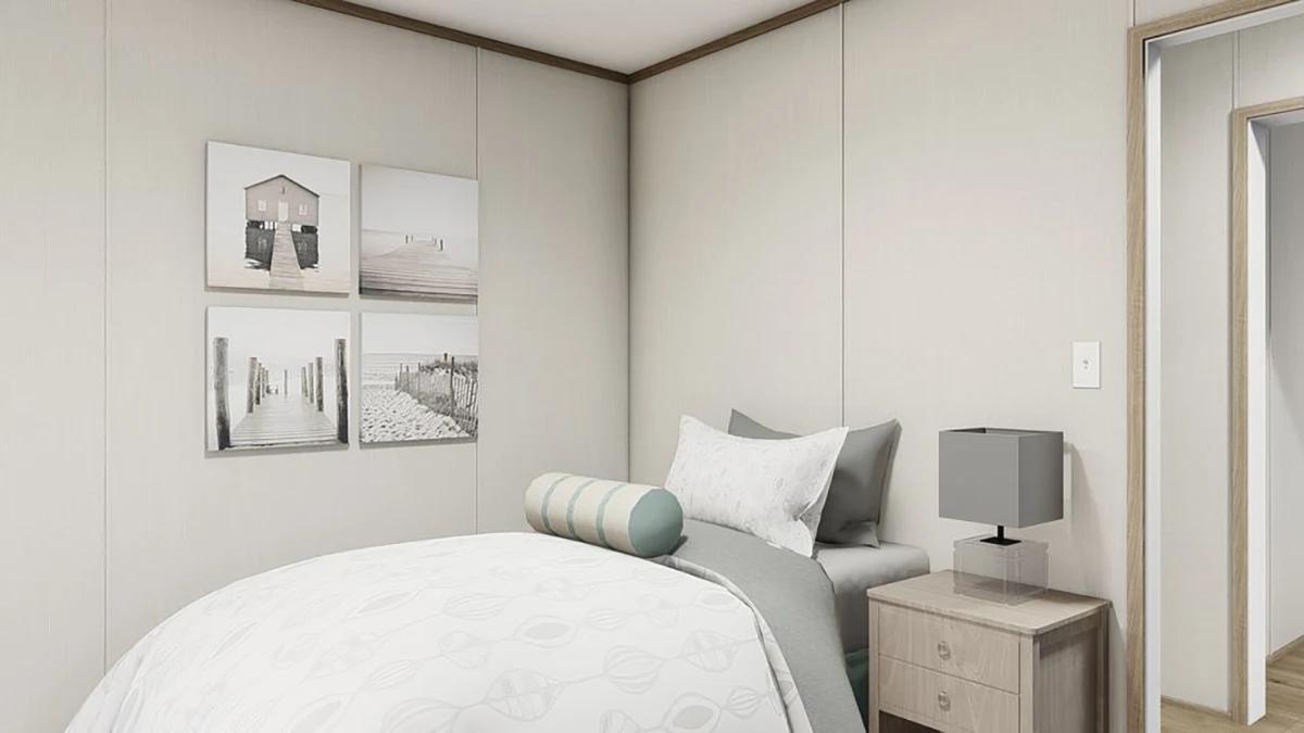 cb21b190-cc30-4605-9c75-cc8abac2fb36 A modern bedroom with a neatly made bed, gray and white bedding, a round bolster pillow, wall art, a nightstand with a lamp, and a mirror reflecting part of the room.