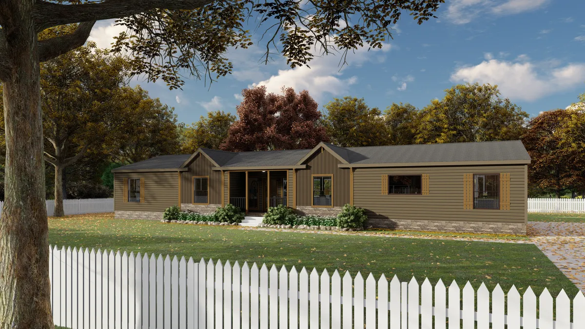 cc16956b-c59d-4d1e-89bd-31e7a0903eea Single-story brown house with a covered porch, stone foundation, and large windows, surrounded by a white picket fence and trees with autumn foliage.