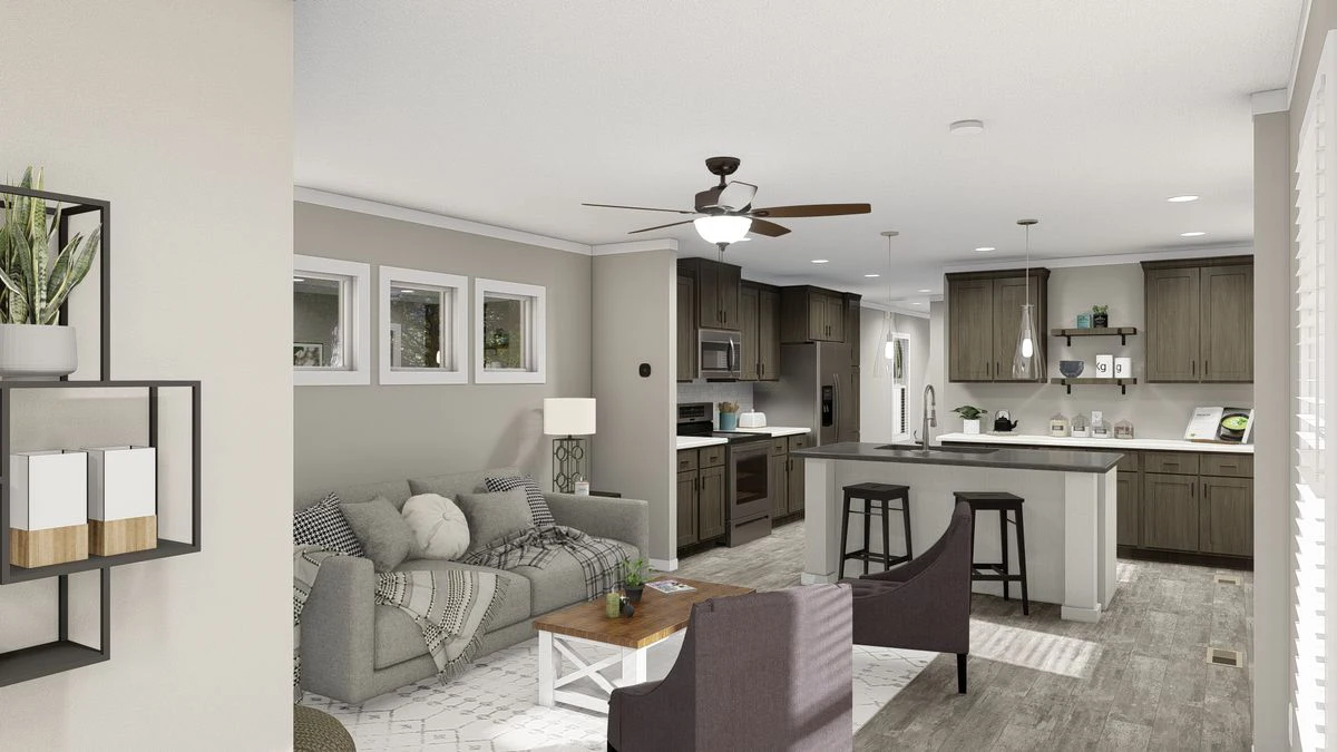 Open-concept living room and kitchen with gray and white decor, a sofa, coffee table, kitchen island with chairs, and ceiling fan, featuring modern furnishings and natural light.