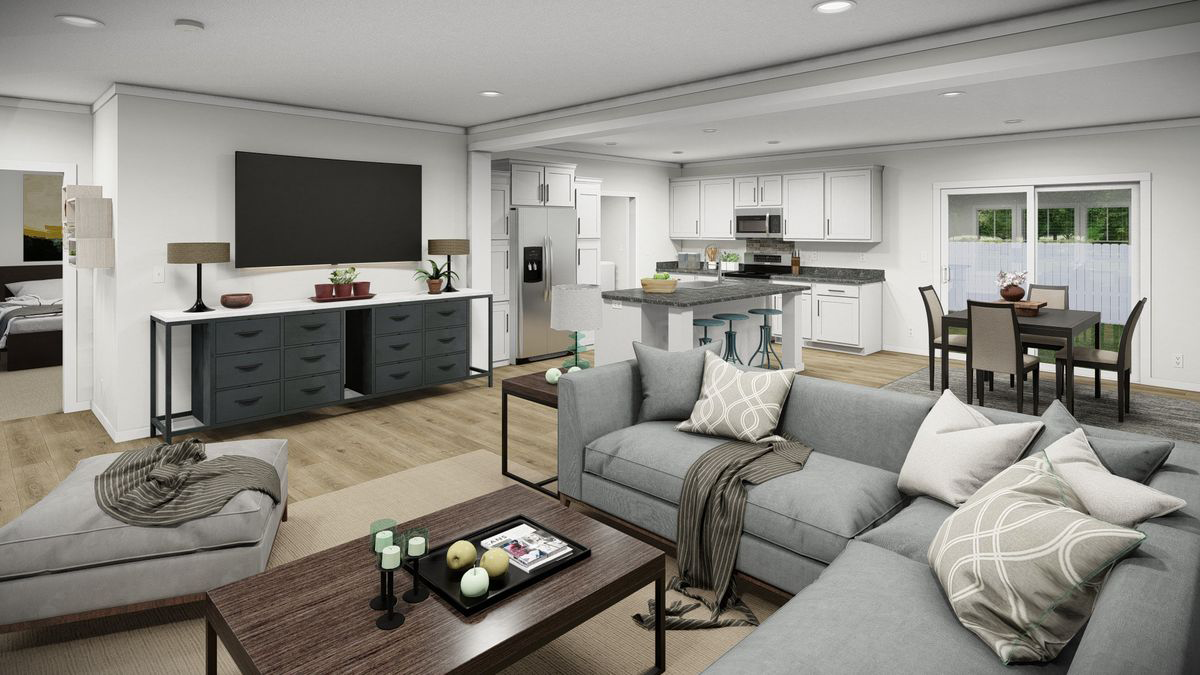 d319860a-3d03-499f-9629-2fb47f66b5b4 Modern open-plan living room and kitchen with gray sofas, a coffee table, dining area, and white cabinetry; large windows provide natural light.