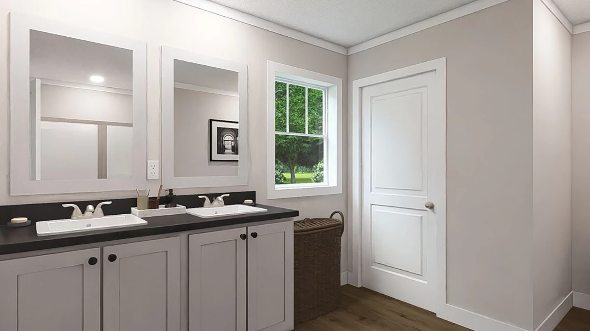 d3afdab8-ed66-41c0-b80d-93eae47bbfb1 Modern bathroom with double sinks, white cabinets, a window showing greenery outside, a wicker laundry basket, and a closed white door.