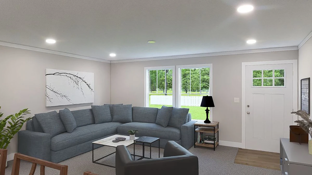 A modern living room with a gray sectional sofa, a black armchair, coffee table, wall art, lamp, and large windows letting in natural light.