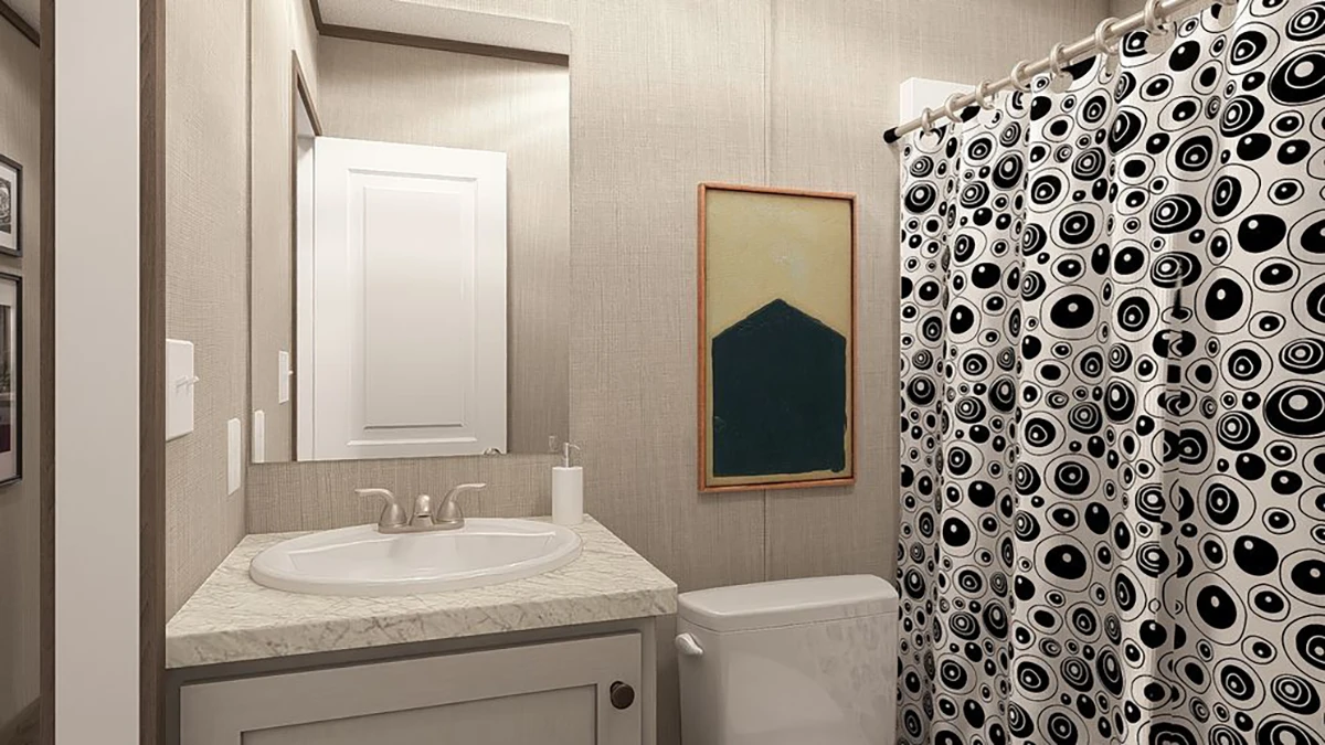 Small bathroom with a sink, mirror, abstract artwork, white door, and a shower with a black-and-white patterned curtain.