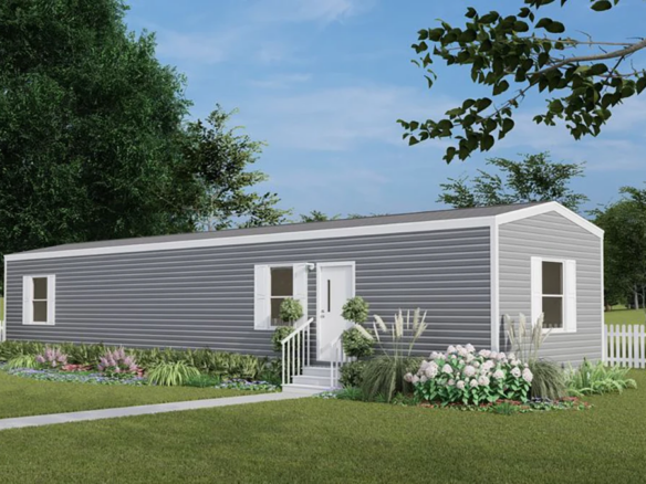 A gray single-wide manufactured home with white trim, small front steps, landscaped garden, white picket fence, and green lawn under a blue sky.