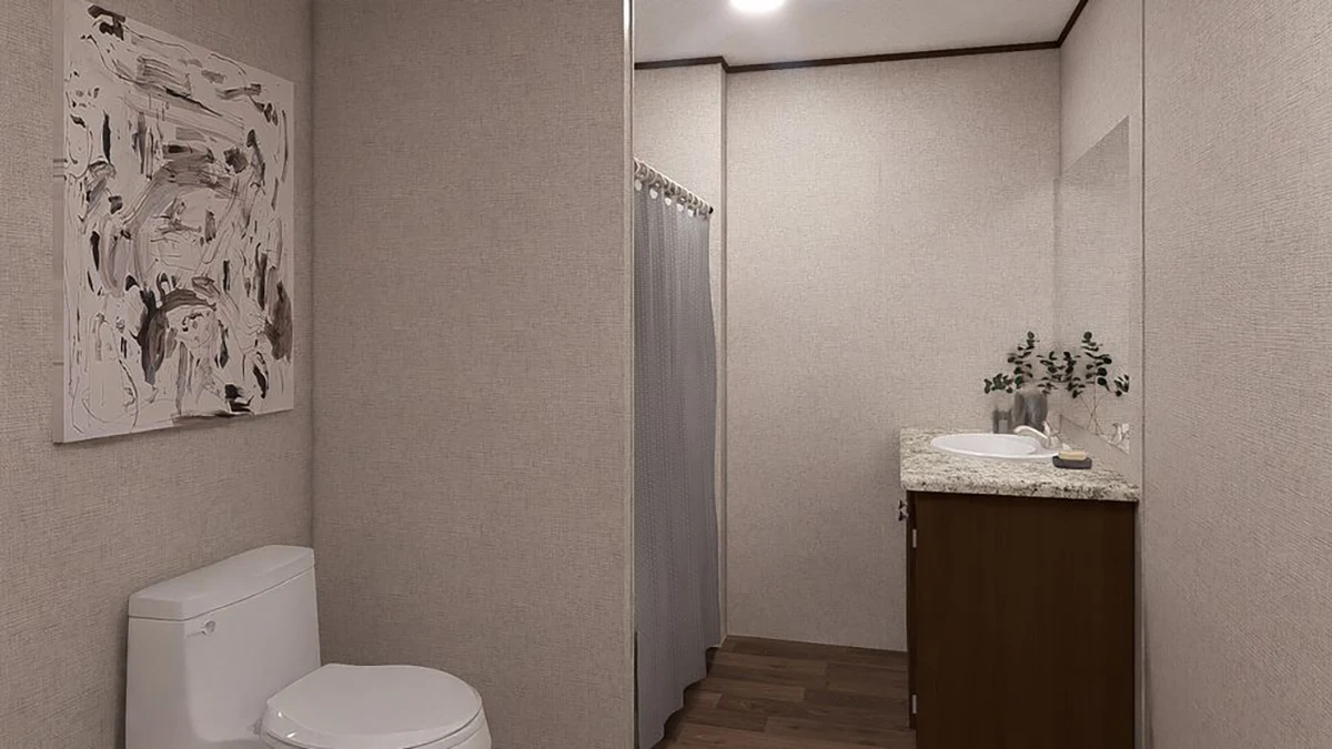 A modern bathroom with a toilet, abstract art on the wall, a shower with a curtain, a sink on a wooden vanity, and a countertop with a small plant.