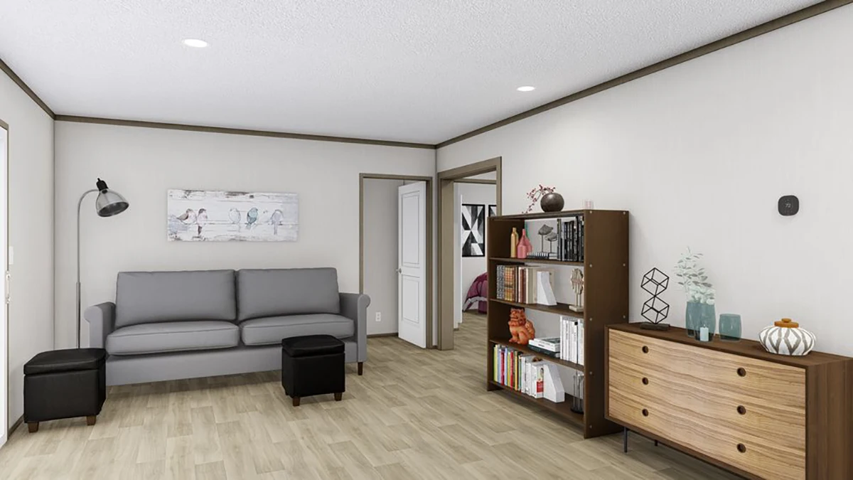 A modern living room with a gray sofa, two black ottomans, a bookshelf, a wooden dresser, and wall art, featuring wood flooring and neutral-colored walls.