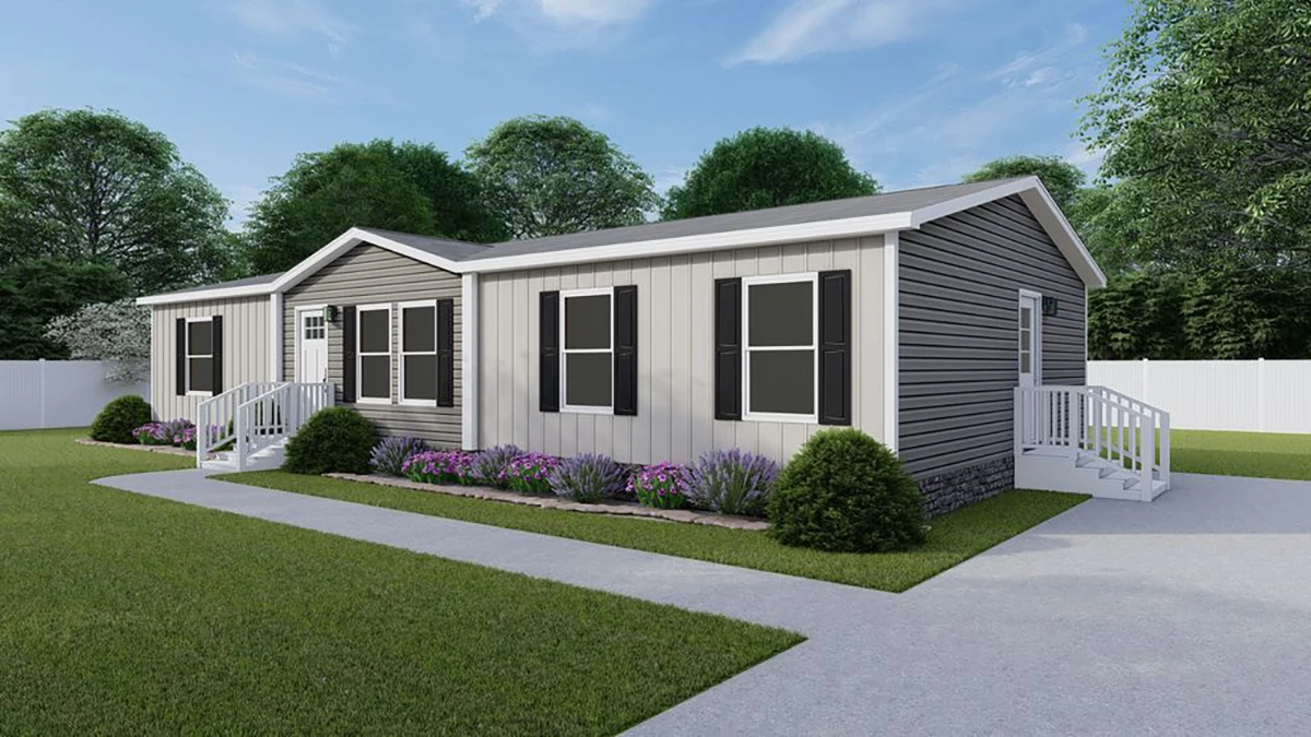 A single-story manufactured home with gray siding, black shutters, white trim, and steps leading to two entrances, surrounded by green lawn and flower beds.