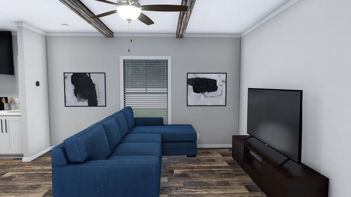e05fa145-4016-45f4-832c-b953accd5956 A modern living room with a blue sectional sofa, large flat-screen TV on a wooden stand, two abstract art pieces on the walls, and a ceiling fan.