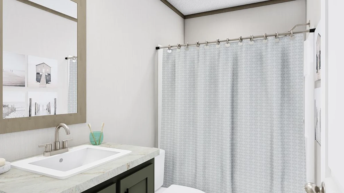 A bathroom with a sink, faucet, mirror, toothbrush holder, framed pictures on the wall, and a shower with a light-patterned curtain.
