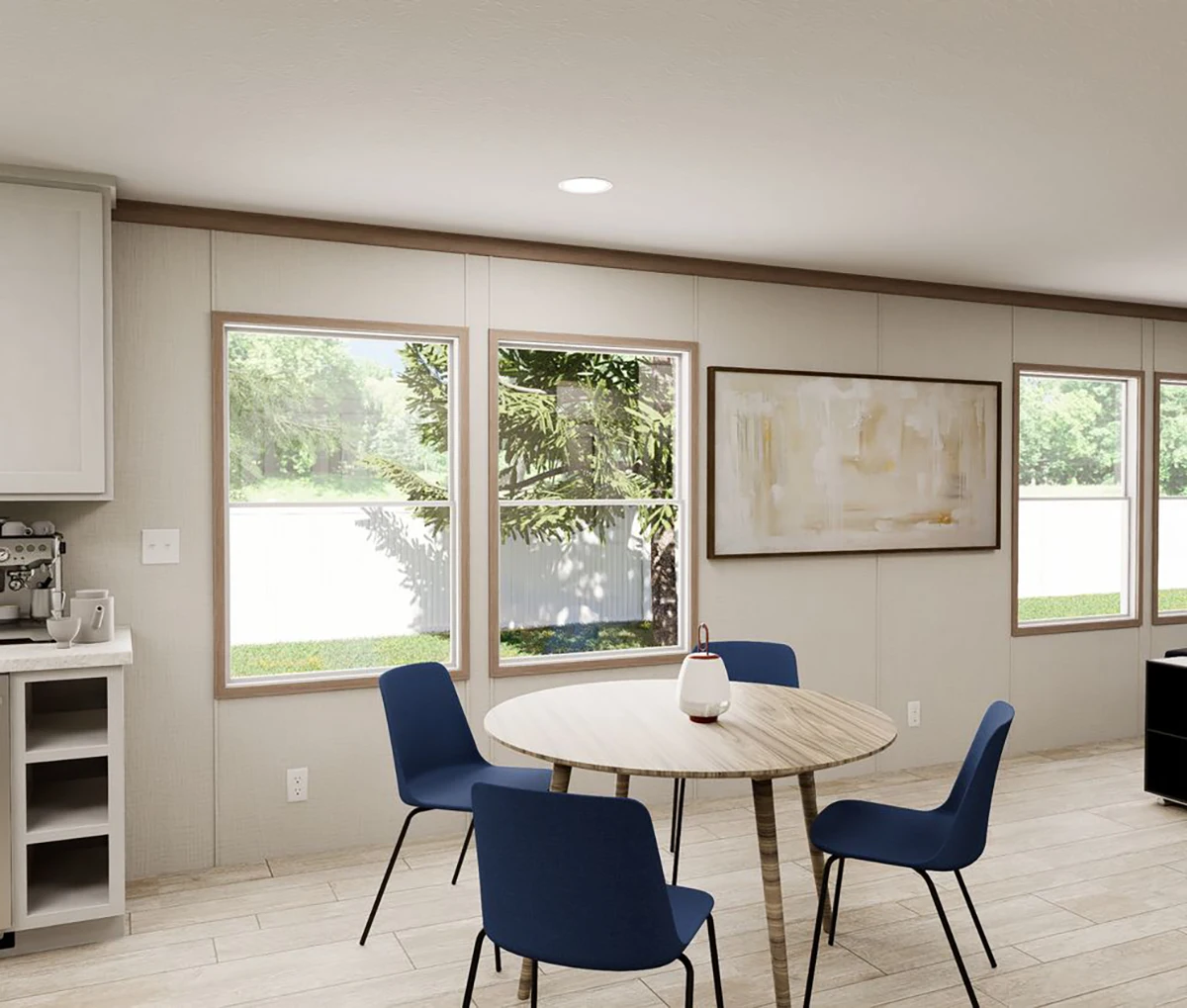 A modern dining area with a round wooden table, four blue chairs, large windows, abstract wall art, and a coffee machine on the side counter.