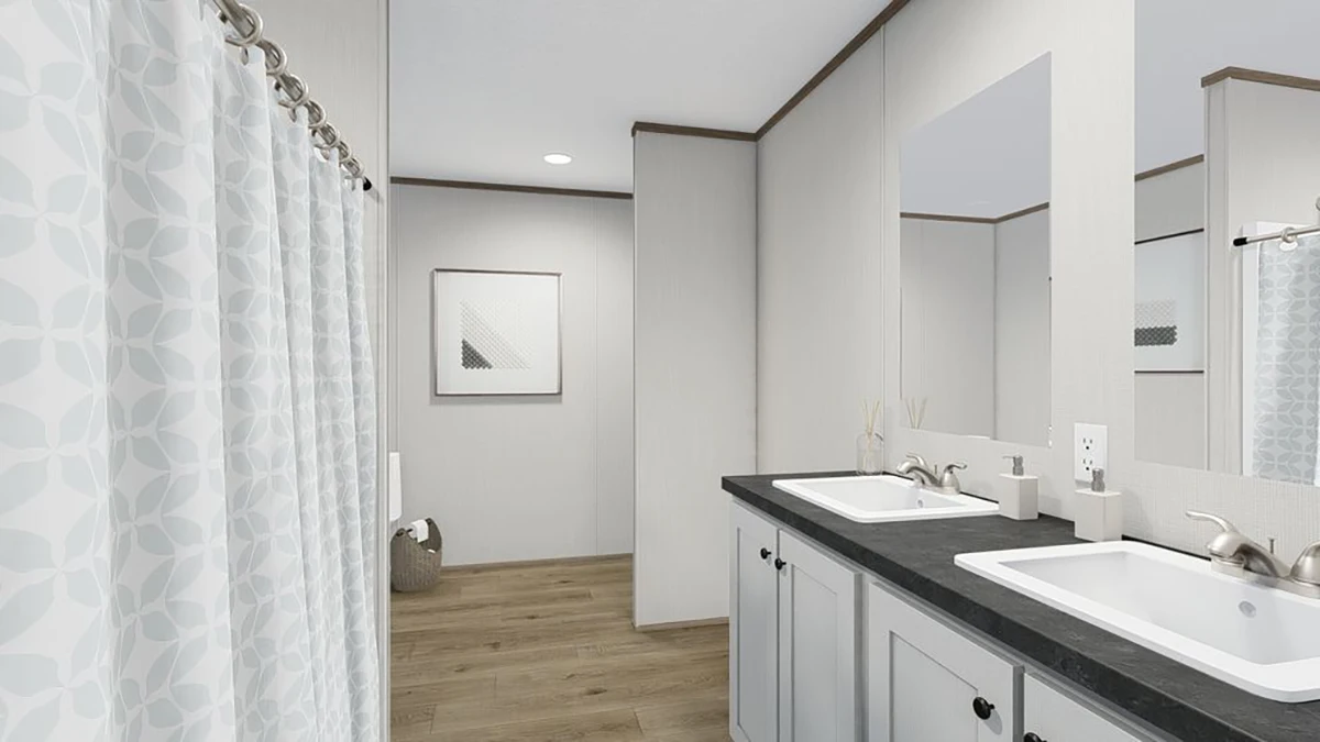 Modern bathroom with double sink vanity, black countertops, light gray cabinets, a shower with patterned curtain, wood-style flooring, and a framed picture on the wall.