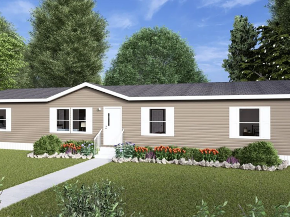 A single-story manufactured home with beige siding, white trim, a dark roof, a small porch, and a landscaped front yard with flowers and shrubs.