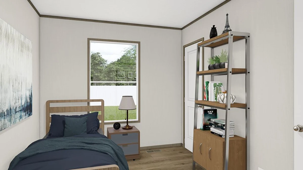 A small bedroom with a single bed, nightstand, lamp, bookshelf, and a window showing a view of a fenced yard with trees.