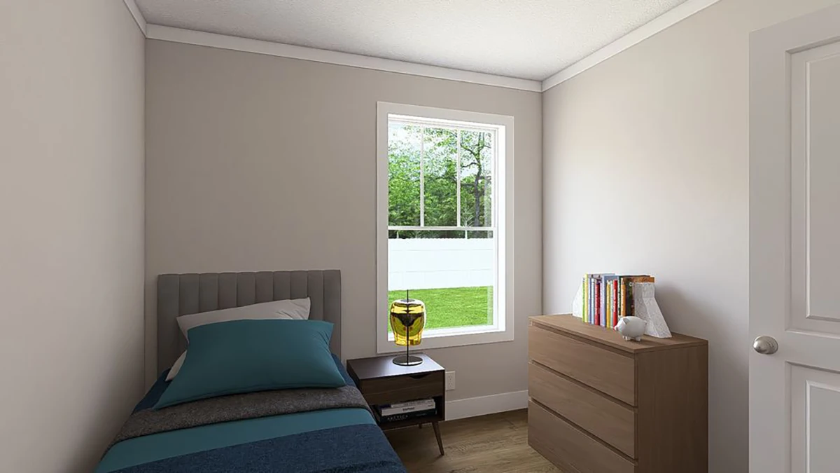 A small bedroom with a single bed, nightstand, dresser with books and decor, and a window overlooking a green yard.