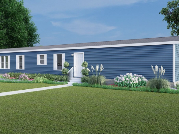 A blue single-story manufactured home with white trim, a central front door, several windows, and landscaped garden beds in a grassy yard.