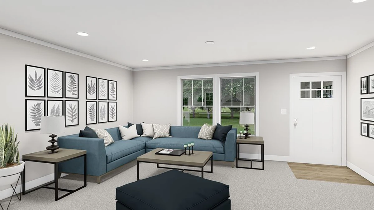 ee39d4db-bad7-41f0-bde6-b4376e9be4bd A modern living room with a blue sectional sofa, two side tables with lamps, a large ottoman, framed leaf art on the walls, and a window and white front door in the background.