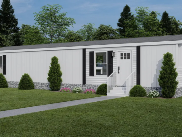 A single-wide manufactured home with white siding, black shutters, a small porch, and landscaped shrubs on a grassy lawn with trees in the background.