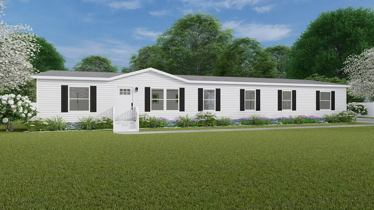 f0b0c848-f17d-489a-be5b-6593b3fce125 A single-story white manufactured home with black shutters, front steps, and a landscaped yard, set against green grass and trees under a blue sky.