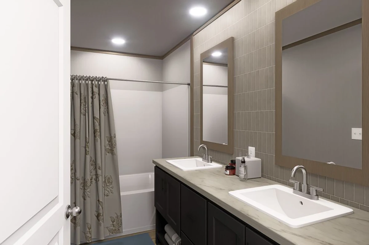 Modern bathroom with double sinks, dark cabinetry, two mirrors, and a shower-tub combination with a floral curtain. Overhead lights illuminate the space.