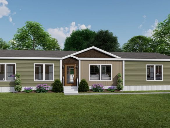 A single-story manufactured home with green and beige siding, multiple windows, a central front door, shrubs, and a manicured lawn, set against a backdrop of trees and blue sky.