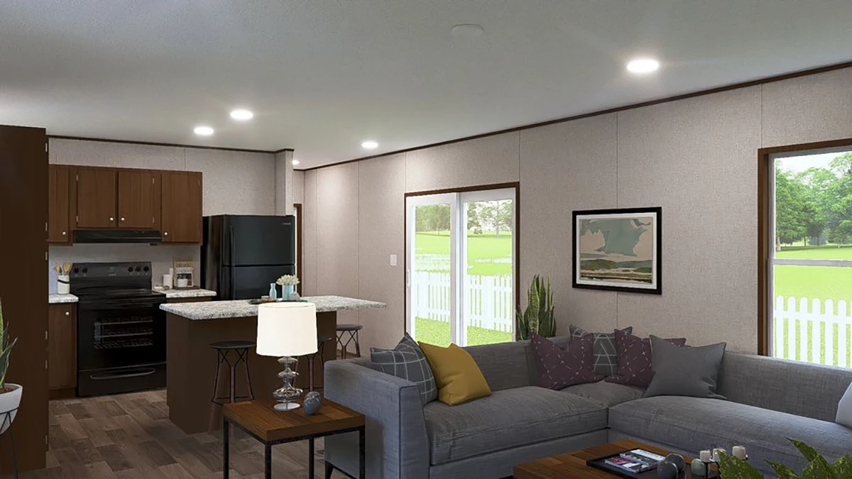 f63f6119-69ff-4426-b427-c076370686cc Modern living room with gray sectional sofa, coffee table, and lamp, open to a kitchen with dark cabinets and black appliances; large windows show a fenced yard with green grass and trees.