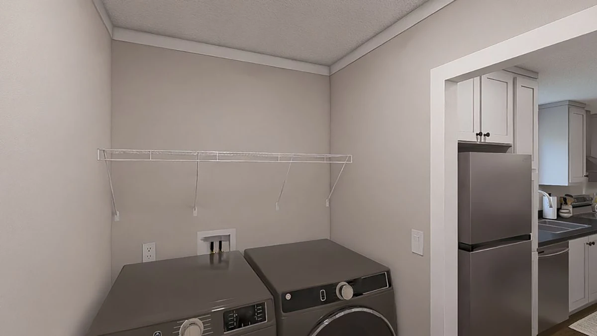 f8c6cdcf-ed6c-4b60-a99c-6d1a01c07aaa A laundry room with a washer and dryer beneath a wire shelf, next to an open doorway leading to a kitchen with stainless steel appliances.