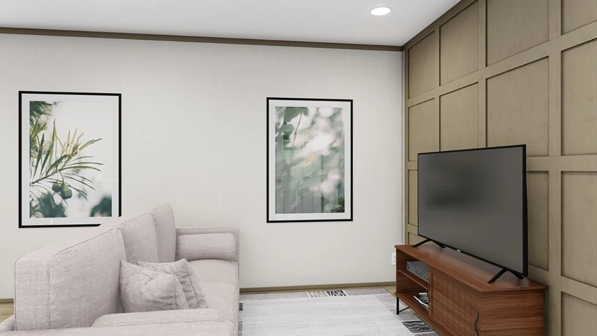 A living room with a light-colored sofa, two framed botanical prints on the wall, a flat-screen TV on a wooden stand, and a paneled accent wall.
