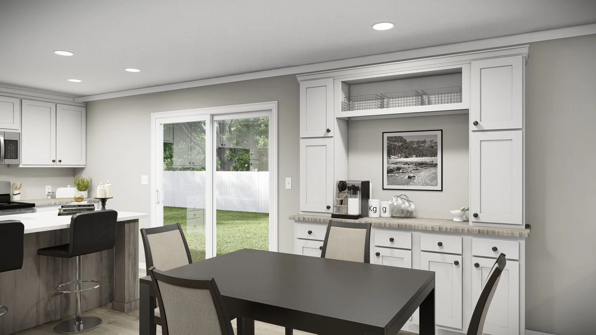 fb1bcc38-721a-4ff3-bb53-68867a94b3a0 A modern kitchen and dining area with white cabinets, a dark dining table, sliding glass doors, and a view of a grassy backyard.