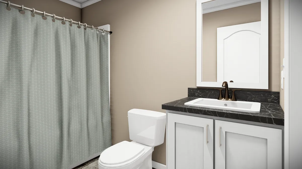 fc59cc2a-633e-48fe-b658-a9c2466f10fd A bathroom with a white toilet, a vanity with a black countertop and sink, a wall mirror, and a shower with a light-colored curtain.
