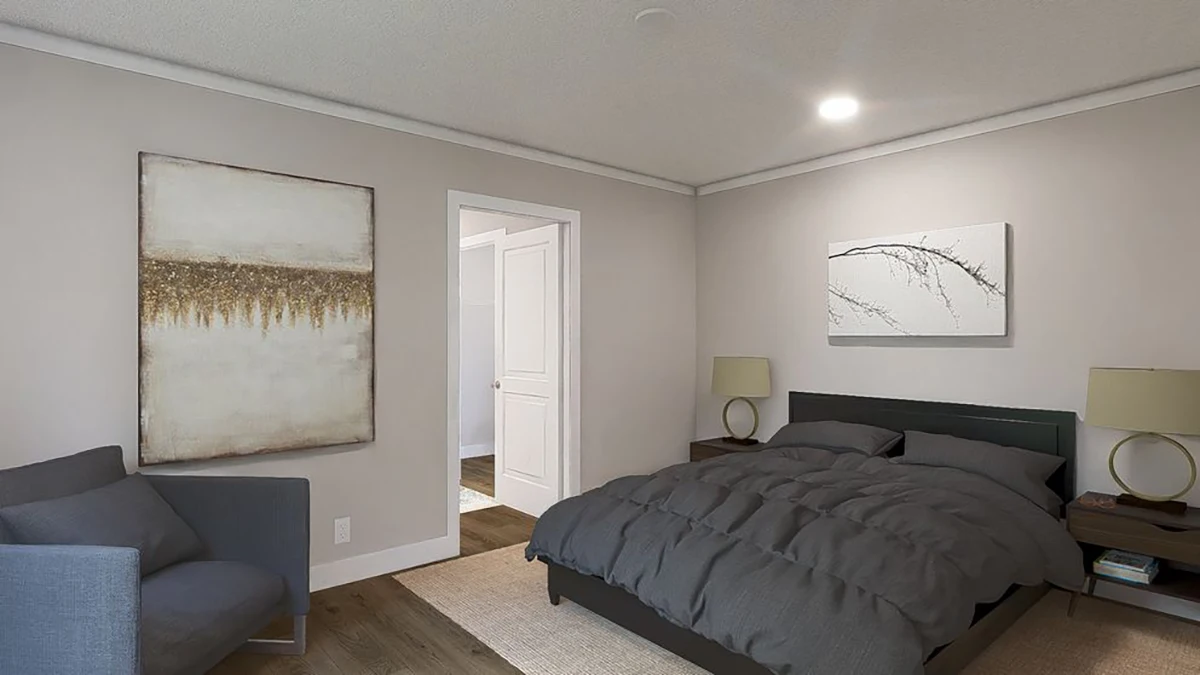 A modern bedroom with a dark bed, two bedside tables with lamps, a gray armchair, light-colored walls, and two abstract paintings.