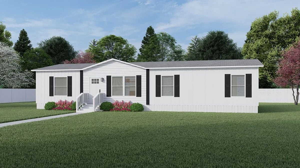 A white single-story manufactured home with black shutters, a small porch, and steps, surrounded by a green lawn and landscaped bushes.