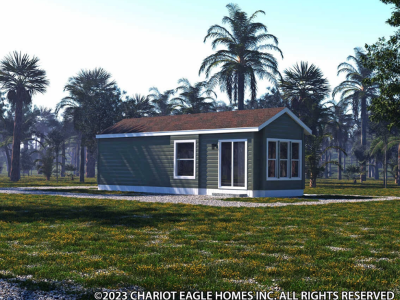 A small green manufactured home with white trim sits on a grassy lot surrounded by palm trees under a clear sky.
