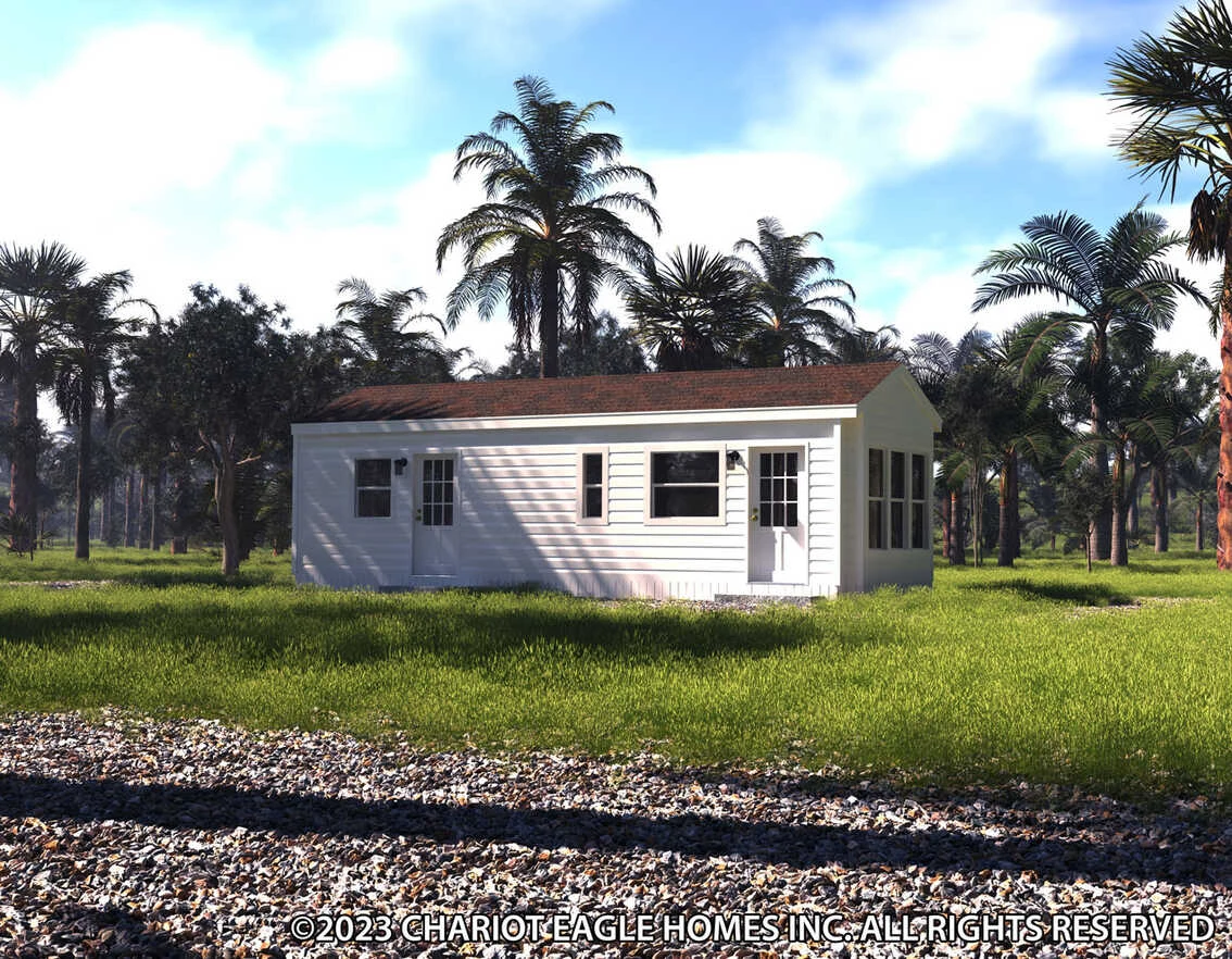 36ee12341c_rf0_1691777199173_1134_12 A white single-story manufactured home sits on a grassy lot surrounded by palm trees, with a gravel area in the foreground.