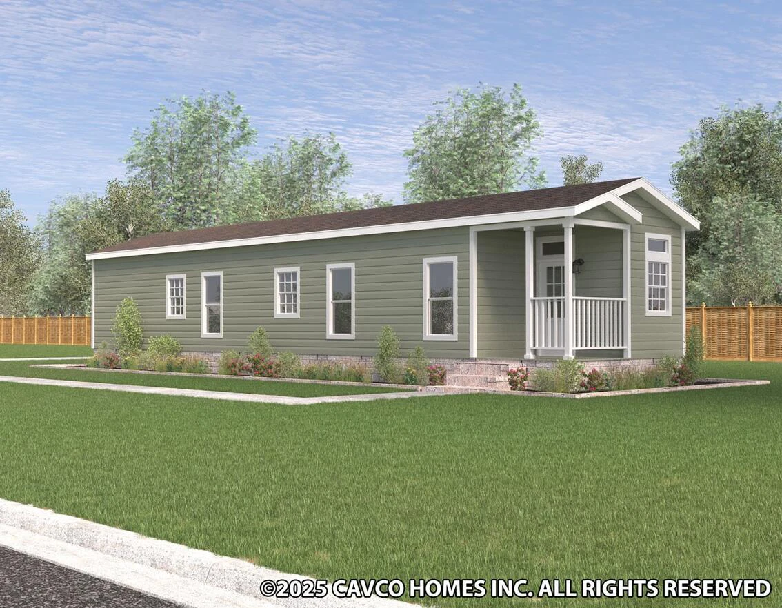 A single-story, green manufactured home with a small covered porch, white trim, and landscaped yard on a grassy lot.