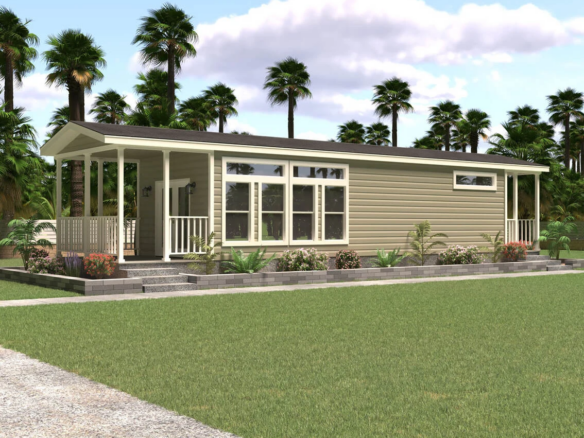 A modern single-story tiny house with beige siding, large windows, and a covered porch, surrounded by landscaped plants and palm trees.