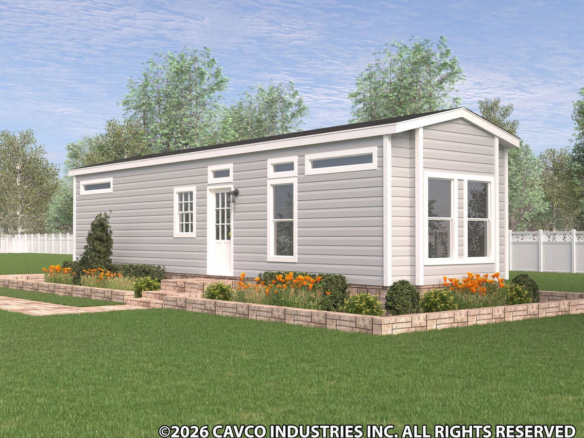 A modern tiny house with light gray siding, white trim, and a gable roof, surrounded by landscaping and a manicured lawn, shown under a partly cloudy sky.
