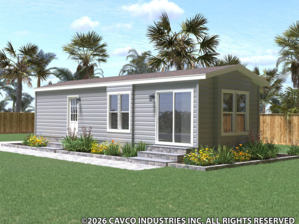 A modern single-story modular home with gray siding, large windows, and a landscaped yard with stone steps, surrounded by a wooden fence and palm trees.