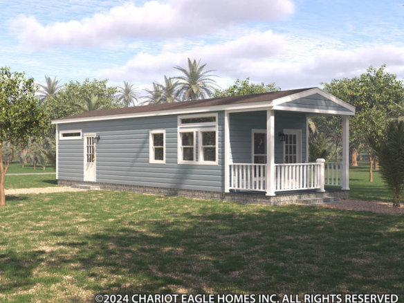 A small blue manufactured home with white trim and a covered front porch, surrounded by trees and grass under a partly cloudy sky.