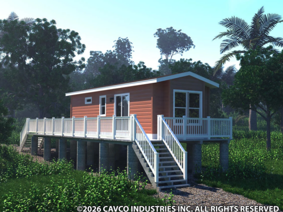A small red house with white trim sits elevated on pillars with a staircase and surrounding deck, set amid green vegetation and palm trees.