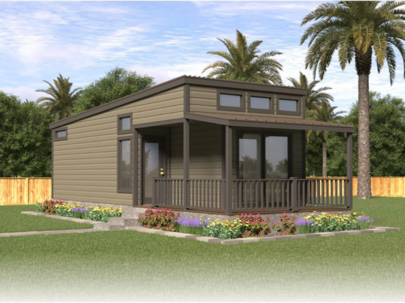 A small modern house with a covered front porch sits in a landscaped yard with flowers, grass, palm trees, and a wooden fence in the background.