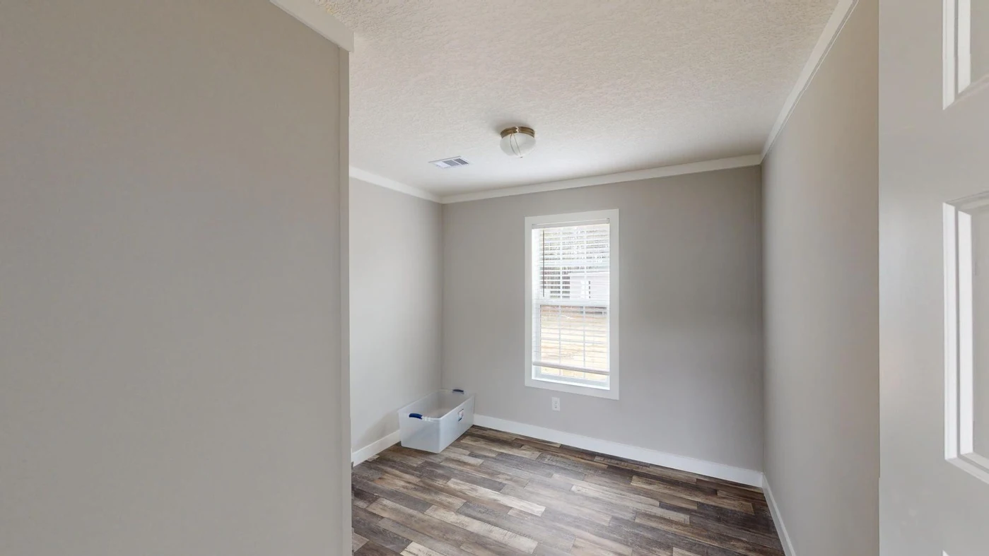 Empty room with gray walls, wood-style flooring, a ceiling light, a window with white blinds, and a plastic storage bin on the floor near the wall.